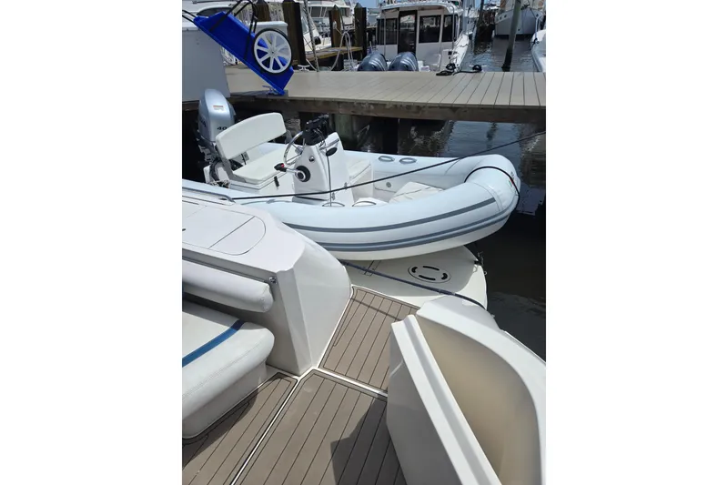 The Image of 2023 AB 11 VSX inflatable boat docked at marina, featuring sleek design and modern seating. - 0
