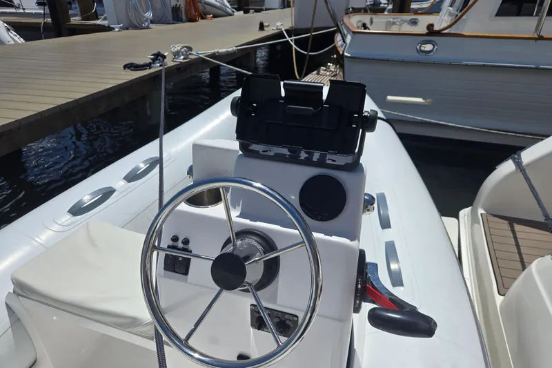 Slide: The Image of 2023 AB 11 VSX boat steering console at dock, featuring modern controls and sleek design. - 3