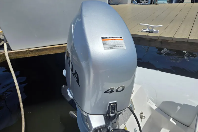 Slide: The Image of Silver outboard motor on a boat, labeled "40," dockside. AB 11 VSX, 2023 model. - 5