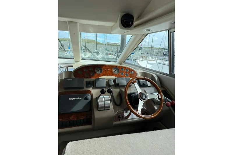 Slide: The Image of 1999 Maxum 4600 SCB yacht helm with Raymarine equipment and wooden steering wheel. - 10