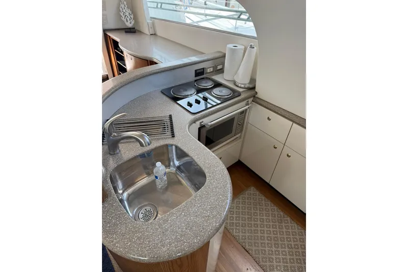 Slide: The Image of 1999 Maxum 4600 SCB yacht kitchen with sink, stove, and microwave. - 12