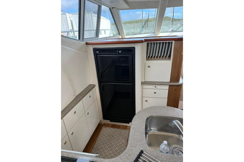 Slide: The Image of 1999 Maxum 4600 SCB yacht interior with kitchen, sink, and storage cabinets. - 13