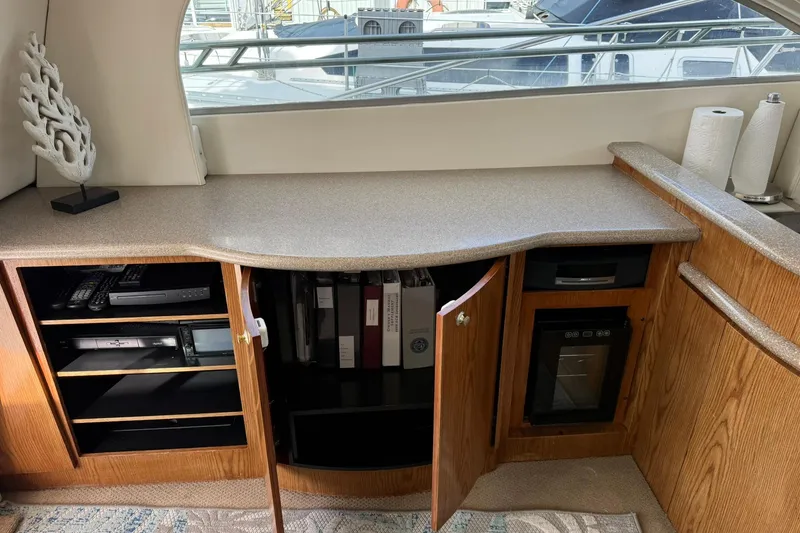 Slide: The Image of 1999 Maxum 4600 SCB yacht interior with open cabinets, electronics, and decorative items. - 15