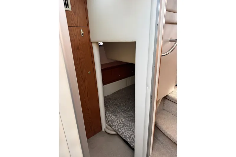 Slide: The Image of 1999 Maxum 4600 SCB yacht interior with cozy sleeping quarters and wooden cabinetry. - 17