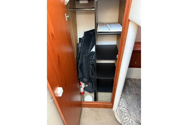 Slide: The Image of Interior storage of 1999 Maxum 4600 SCB yacht with shelves and hanging space. - 19