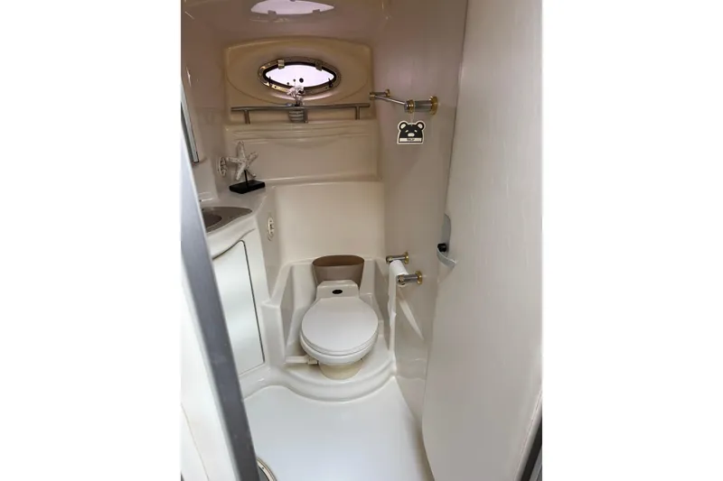 Slide: The Image of 1999 Maxum 4600 SCB yacht bathroom with toilet, sink, and porthole window. - 20