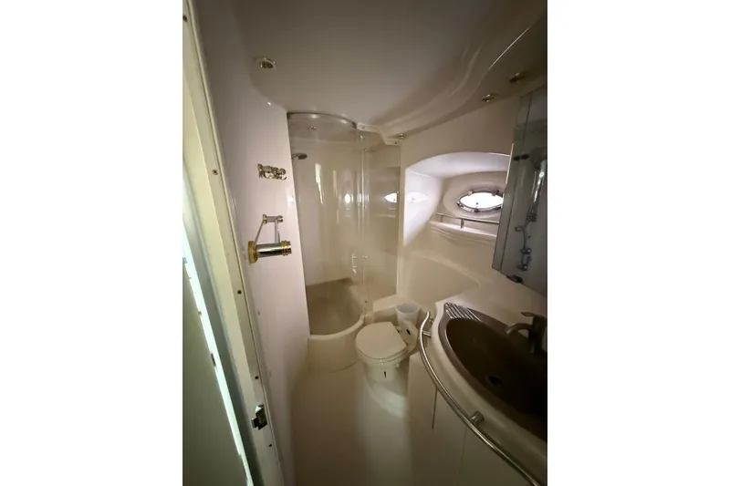 Slide: The Image of Bathroom interior of 1999 Maxum 4600 SCB yacht, featuring shower, sink, and porthole window. - 25