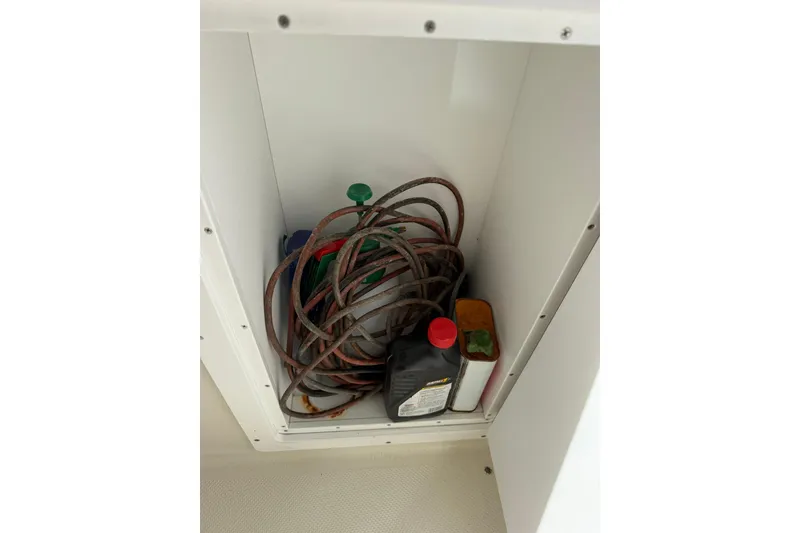 Slide: The Image of Storage compartment in Maxum 4600 SCB boat with cables and bottles. - 4