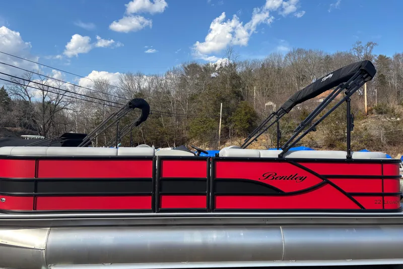 Slide: The Image of 2026 Bentley Pontoons Legacy 220 Cruise XL, red and black design, under blue sky. - 9