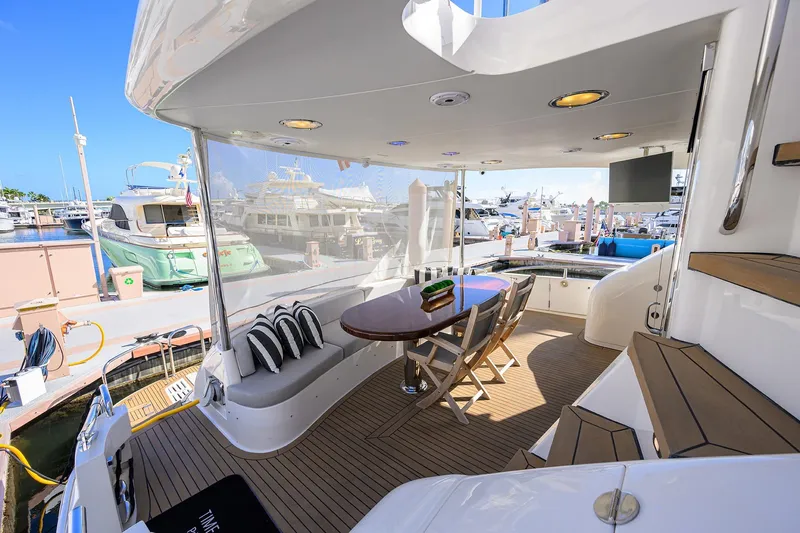 Slide: The Image of Luxurious 2005 Lazzara 68 Enclosed Bridge yacht with elegant outdoor seating and marina view. - 10