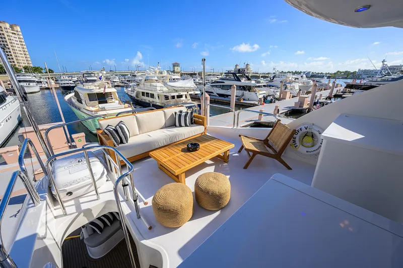 Slide: The Image of Luxurious 2005 Lazzara 68 Enclosed Bridge yacht deck with marina view, featuring elegant seating. - 11