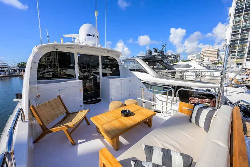 Slide: The Image of 2005 Lazzara 68 Enclosed Bridge yacht with stylish outdoor seating and marina view. - 13