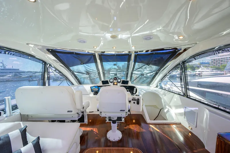 Slide: The Image of 2005 Lazzara 68 Enclosed Bridge yacht interior with helm, luxurious seating, and panoramic windows. - 21