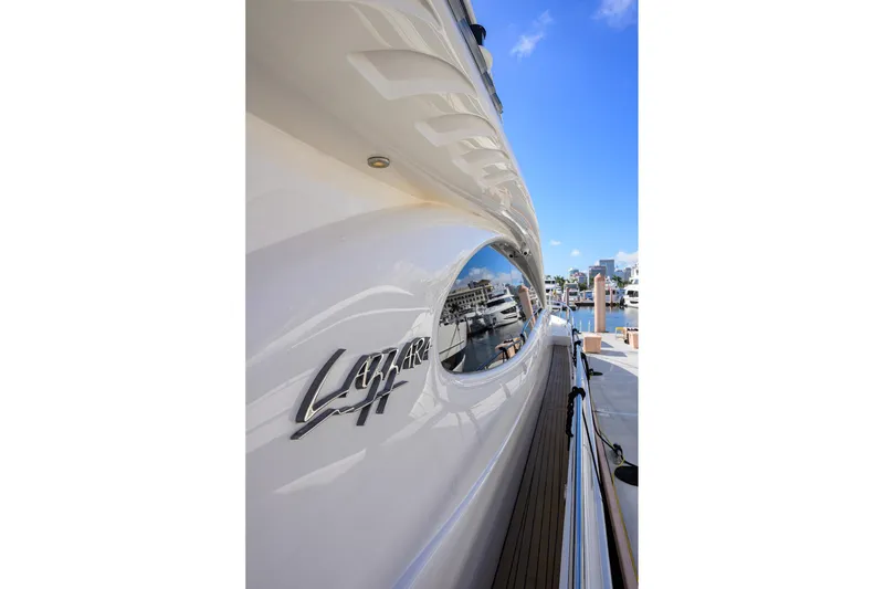 Slide: The Image of 2005 Lazzara 68 Enclosed Bridge yacht docked, showcasing sleek design and marina view. - 26