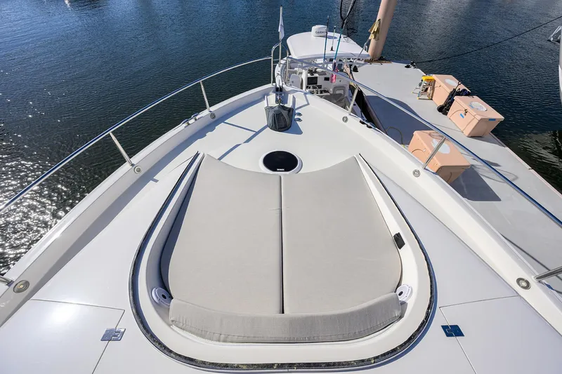 Slide: The Image of 2005 Lazzara 68 Enclosed Bridge yacht deck with sunbed, overlooking calm water. - 28