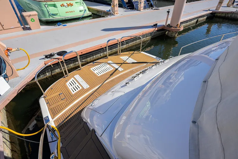 Slide: The Image of 2005 Lazzara 68 Enclosed Bridge yacht docked at marina with wooden deck. - 5
