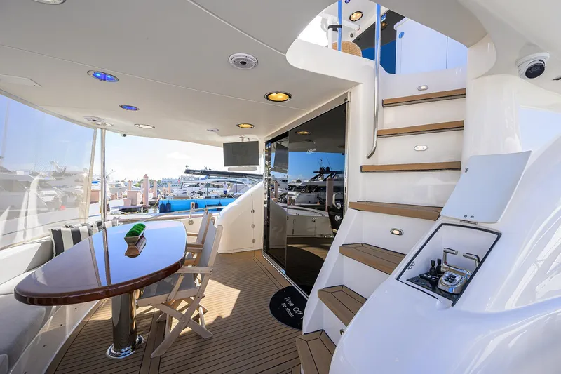 Slide: The Image of 2005 Lazzara 68 Enclosed Bridge yacht interior with table, chairs, and staircase. - 9