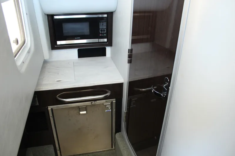 Slide: The Image of 2018 Formula 350 Crossover Bowrider interior with microwave and compact fridge. - 20