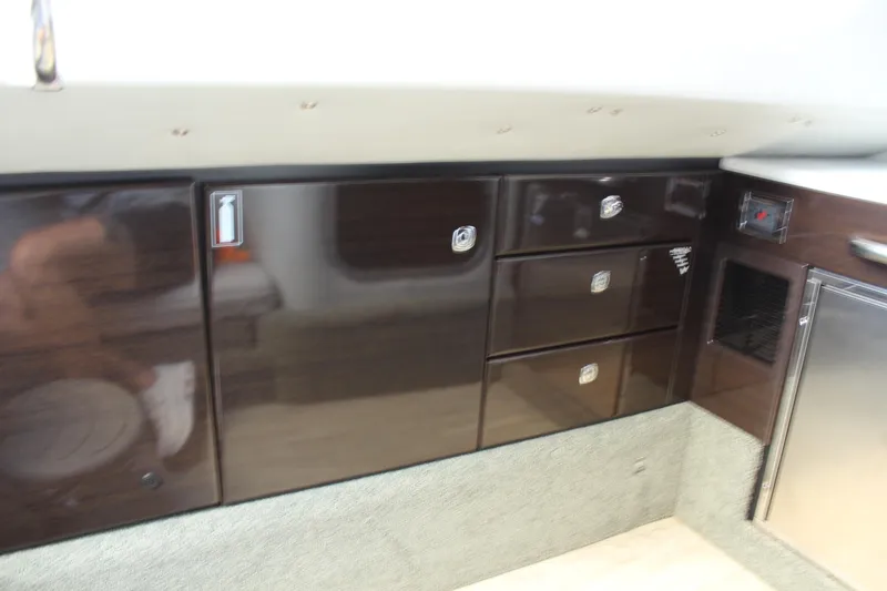 Slide: The Image of 2018 Formula 350 Crossover Bowrider interior cabinetry with dark wood finish and modern design. - 24
