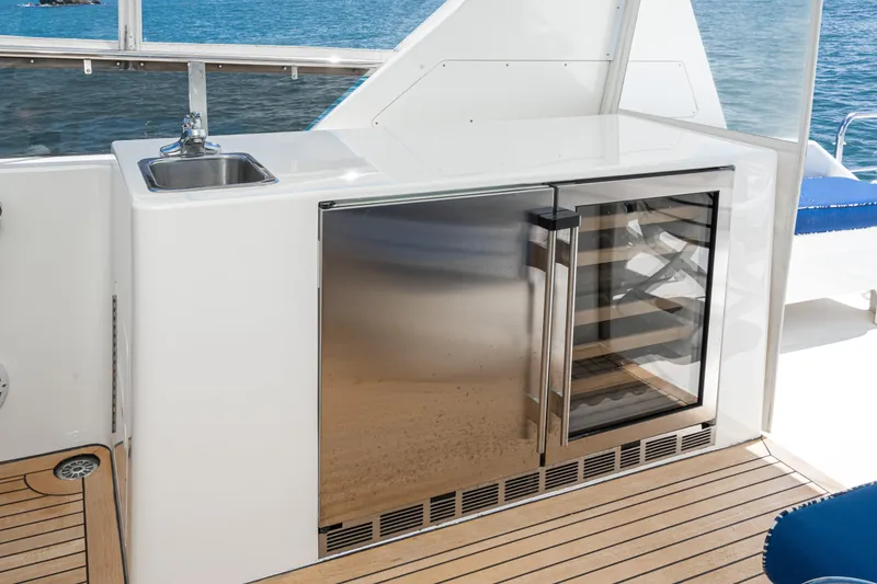 Slide: The Image of Outdoor kitchenette on 2001 West Bay Sonship yacht with sink and stainless steel fridge. - 14