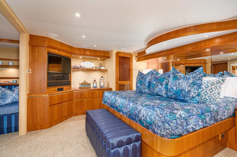 Slide: The Image of Luxurious 2001 West Bay Sonship yacht bedroom with elegant wood finishes and vibrant blue bedding. - 21