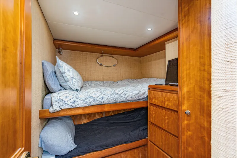 Slide: The Image of Cozy bunk beds in 2001 West Bay Sonship yacht cabin with wooden cabinetry. - 26