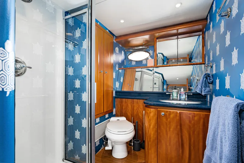 Slide: The Image of Luxurious 2001 West Bay Sonship yacht bathroom with blue turtle wallpaper and wooden cabinetry. - 27