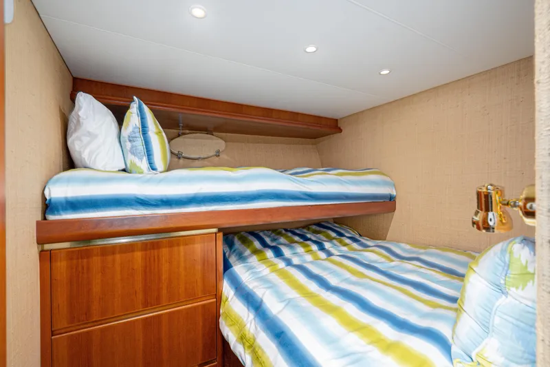 Slide: The Image of 2001 West Bay Sonship yacht cabin with bunk beds and striped bedding. - 32