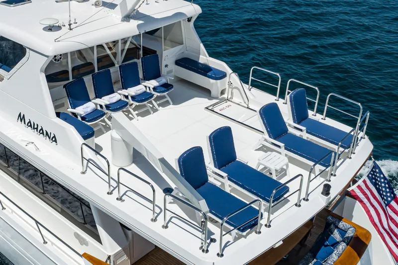 Slide: The Image of Luxurious 2001 West Bay Sonship yacht with blue sun loungers on deck, named "Mahana." - 41