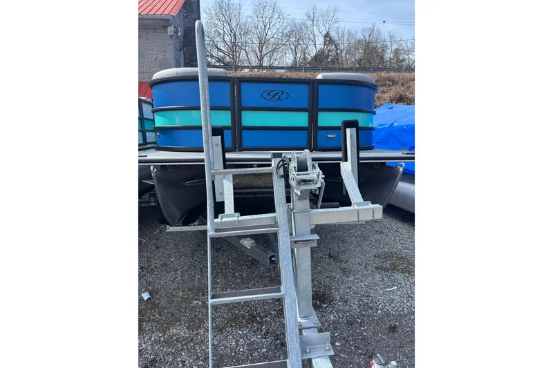 Slide: The Image of 2026 Bentley Pontoons Legacy 220 Cruise XL on trailer, blue exterior, parked outdoors. - 4