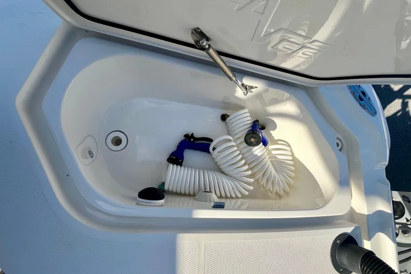 Slide: The Image of Open storage compartment on 2018 SeaVee 270Z boat with coiled hose inside. - 11