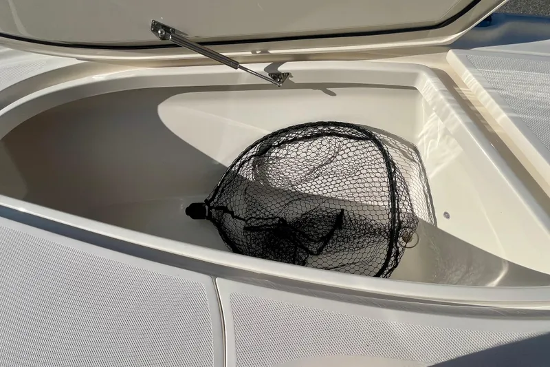 Slide: The Image of Open storage compartment on 2018 SeaVee 270Z boat with a fishing net inside. - 15