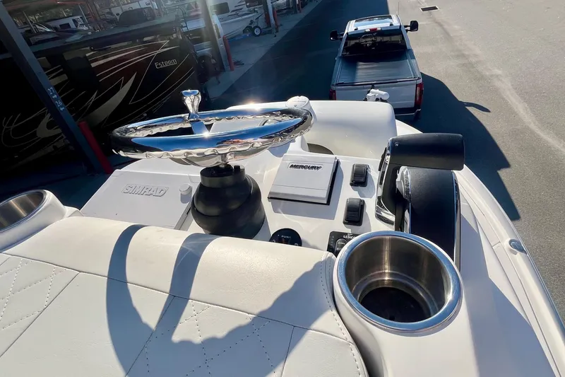 Slide: The Image of 2018 SeaVee 270Z boat helm with steering wheel, controls, and cup holder in sunlight. - 7