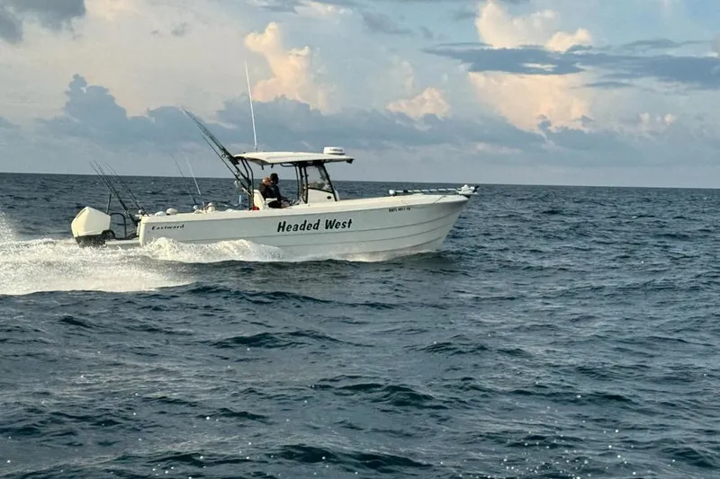 Slide: The Image of Eastward 30 boat cruising on the ocean, 2022 model, with fishing rods and cloudy sky. - 10