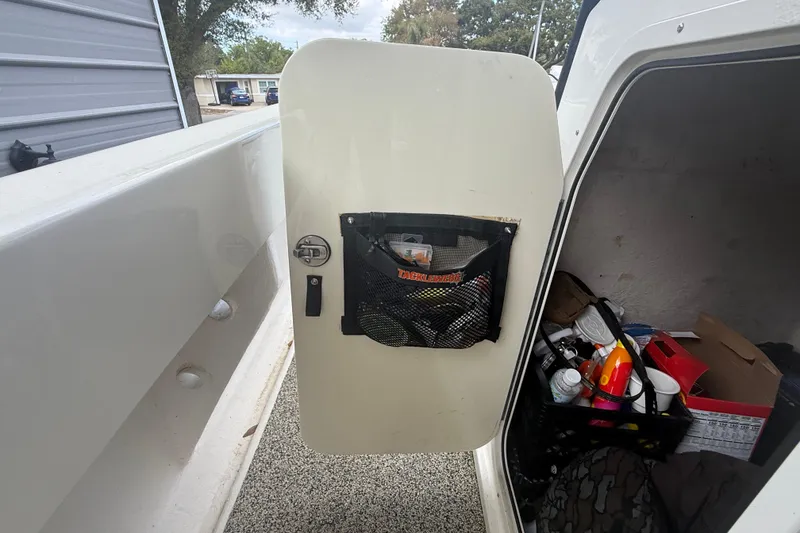 Slide: The Image of Open storage compartment on a 2022 Eastward 30 boat, showing organized supplies. - 102