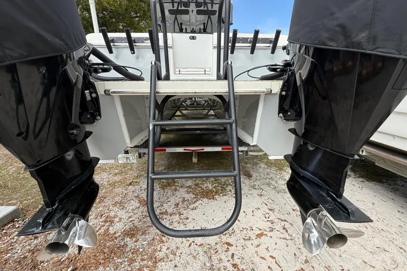 Slide: The Image of Rear view of 2022 Eastward 30 boat with dual outboard motors and ladder. - 119