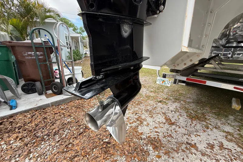 Slide: The Image of Close-up of a 2022 Eastward 30 boat propeller and outboard motor in a yard setting. - 120