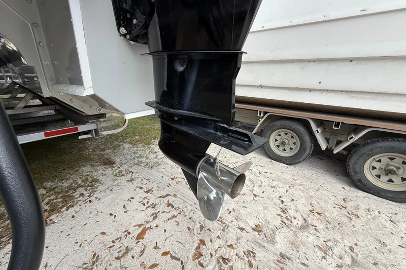 Slide: The Image of Outboard motor of 2022 Eastward 30 boat on trailer, sandy ground. - 121