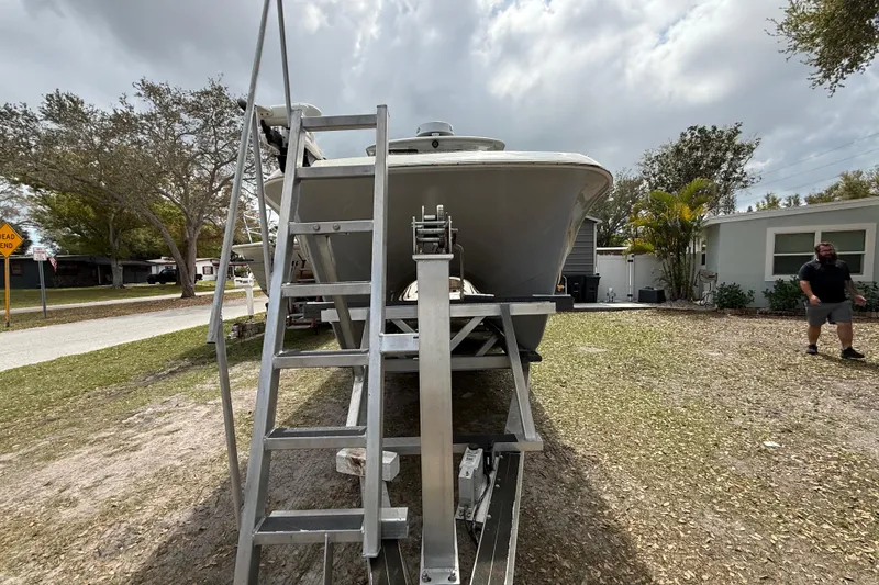 Slide: The Image of 2022 Eastward 30 boat on trailer with ladder, parked in residential area. - 13
