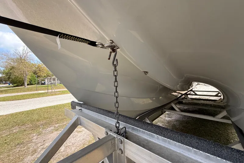Slide: The Image of 2022 Eastward 30 boat hull on trailer, secured with chain and strap. - 16