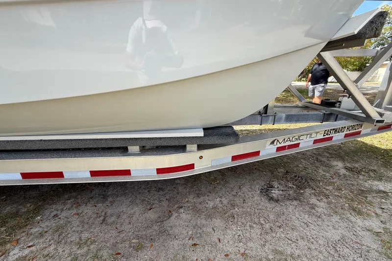 Slide: The Image of Trailer carrying 2022 Eastward 30 boat, Magic Tilt brand, on grassy ground. - 22