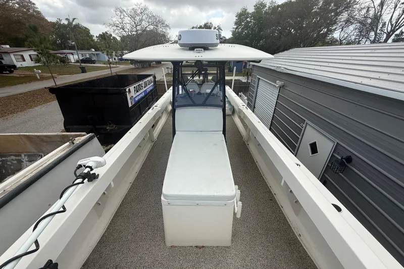 Slide: The Image of 2022 Eastward 30 boat docked beside a metal building, showcasing spacious deck layout. - 28