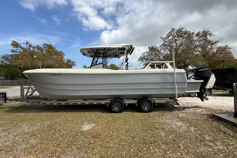 Slide: The Image of 2022 Eastward 30 boat on trailer, parked outdoors under cloudy sky. - 3