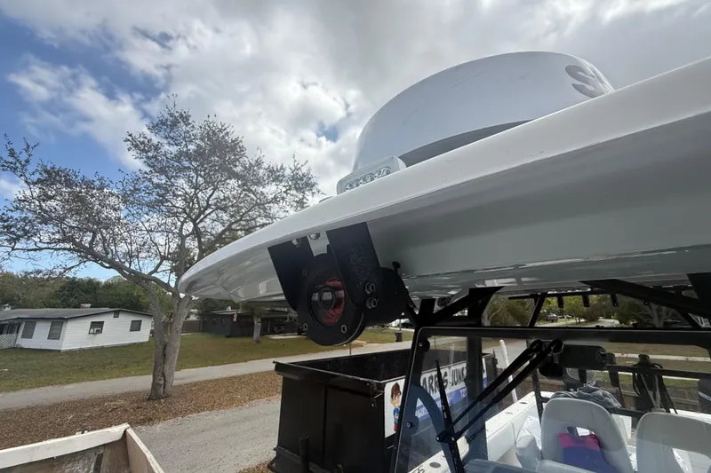 Slide: The Image of 2022 Eastward 30 boat with radar, parked near trees and houses under cloudy sky. - 45