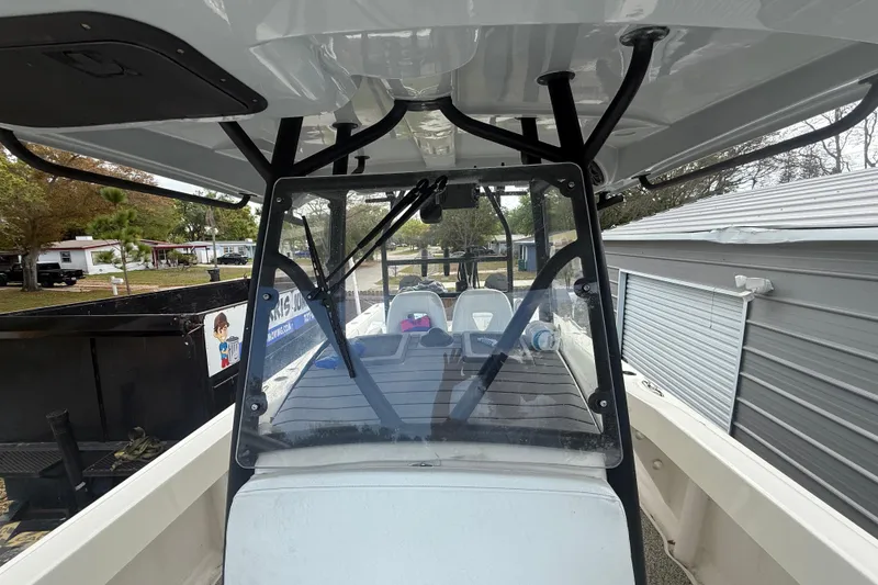 Slide: The Image of 2022 Eastward 30 boat interior with windshield and seating, parked near a garage. - 46