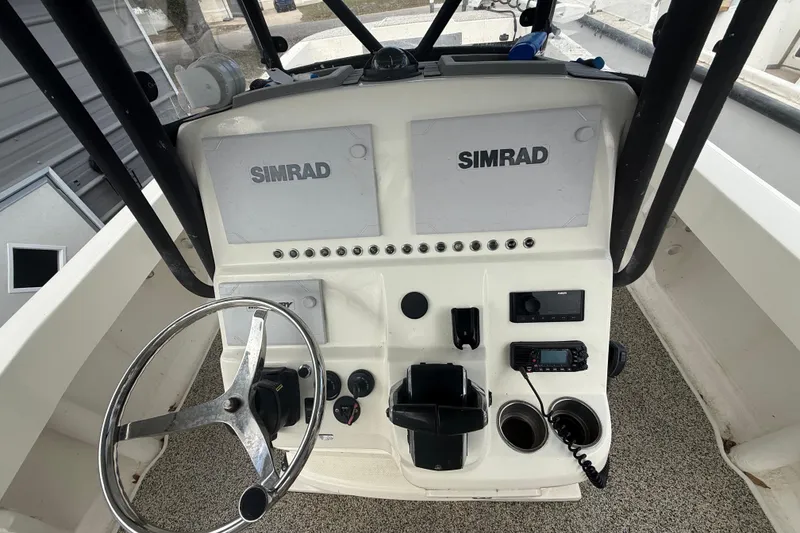 Slide: The Image of Control panel of a 2022 Eastward 30 boat with Simrad displays and steering wheel. - 52
