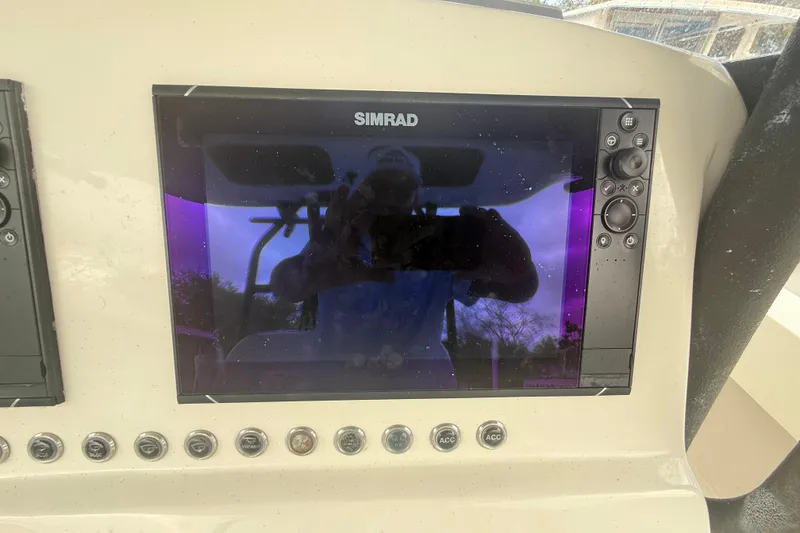 Slide: The Image of Simrad display on 2022 Eastward 30 boat dashboard with control buttons. - 54
