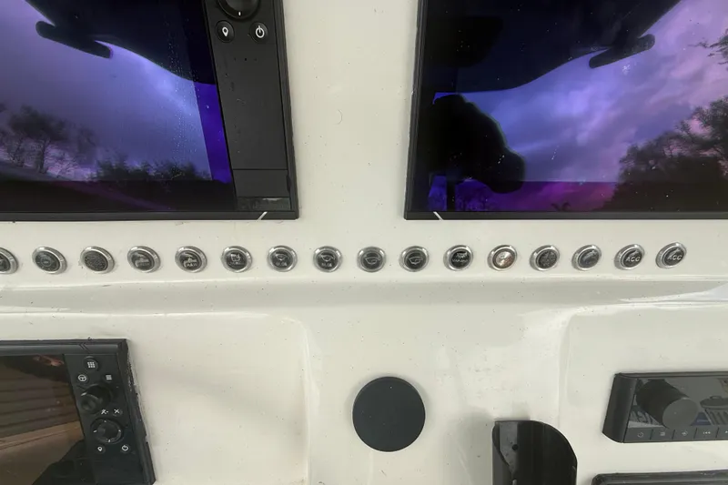 Slide: The Image of Control panel of a 2022 Eastward 30 boat with multiple buttons and screens. - 56