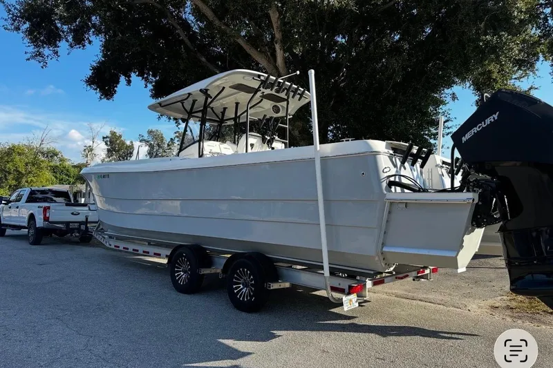 Slide: The Image of 2022 Eastward 30 boat on trailer, parked outdoors, with Mercury outboard motor. - 6