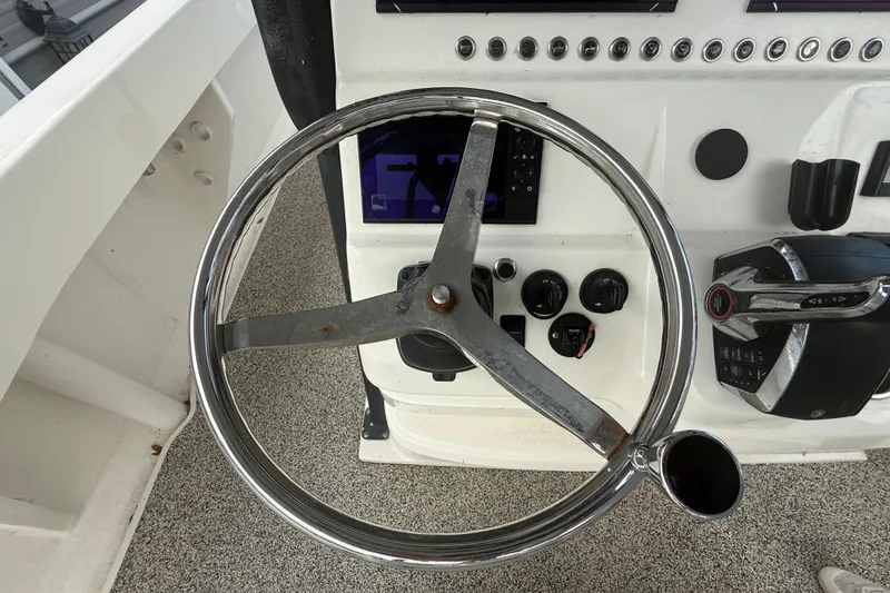 Slide: The Image of Steering wheel and controls of a 2022 Eastward 30 boat cockpit. - 60